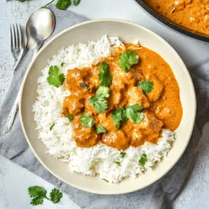 Delicious plate of traditional butter chicken with rice and naan.