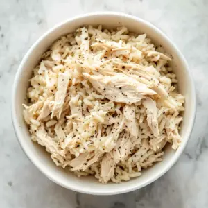 Creamy slow cooker chicken and gravy dish served with fresh herbs