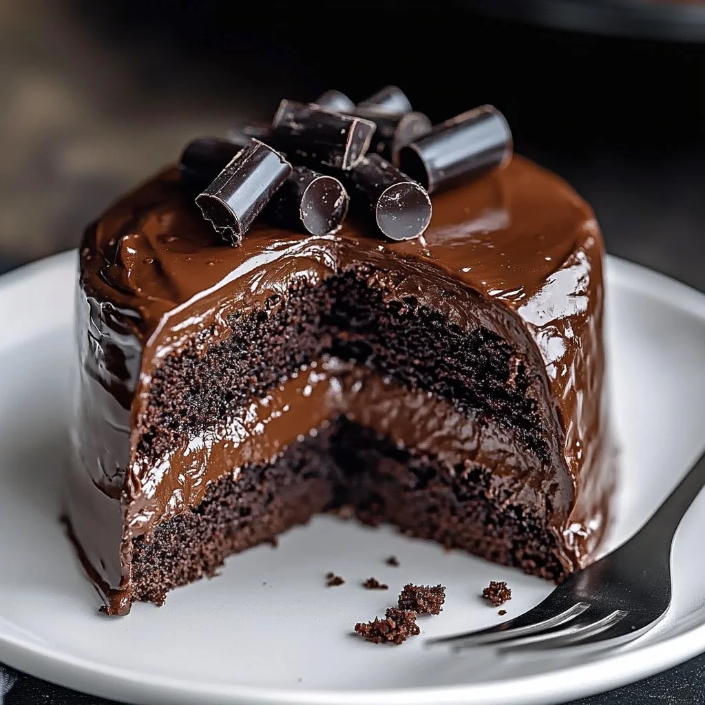 Decadent gluten free chocolate cake topped with frosting and chocolate shavings